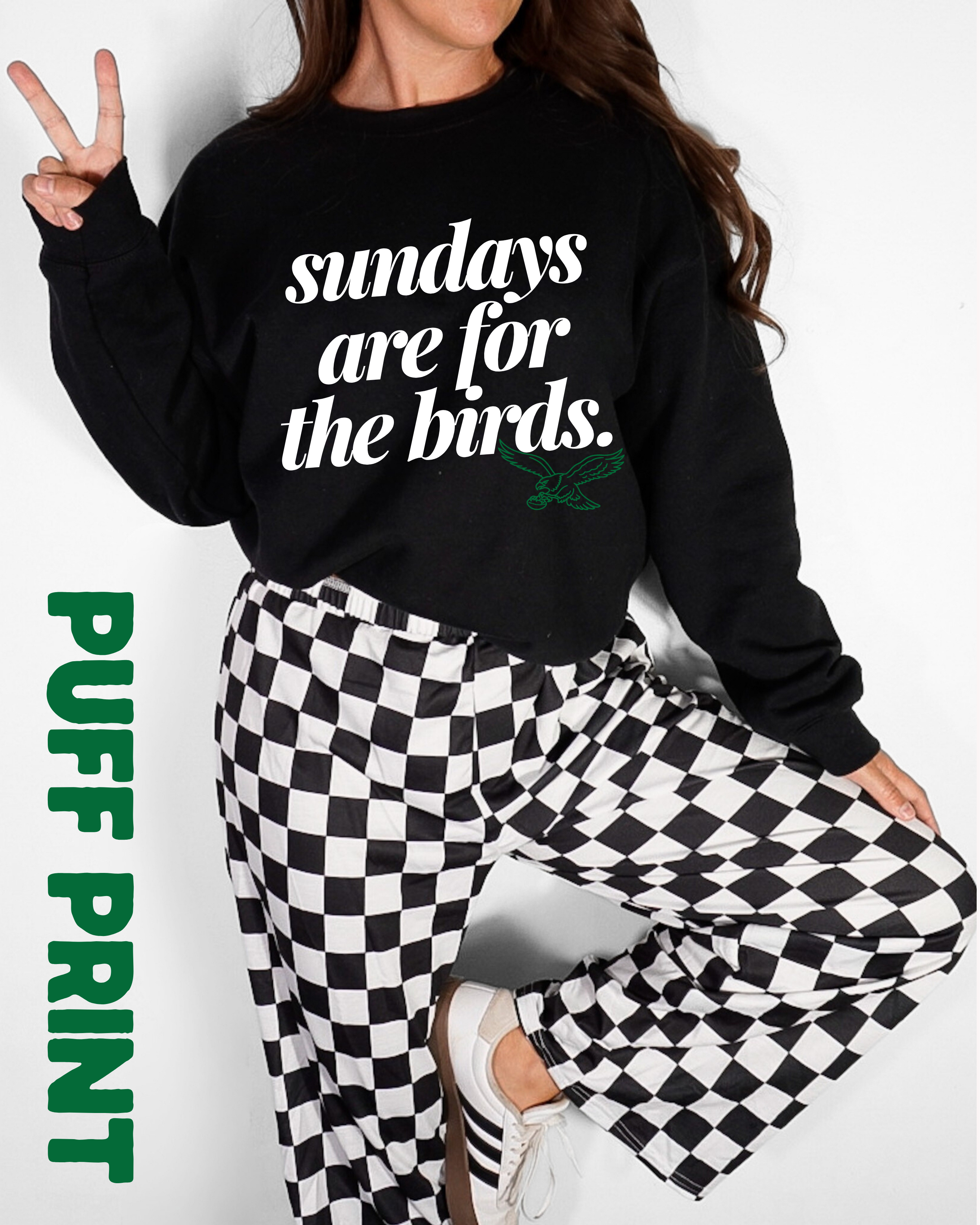 Woman in a black sweatshirt that says Sundays are for the birds in an italic serif font with a small image of a green eagle under.